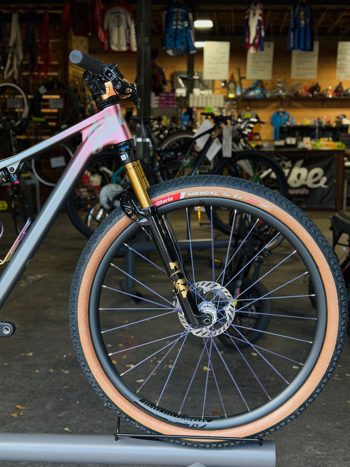 Close-up of a bicycle wheel with a blurred background of a bike shop.