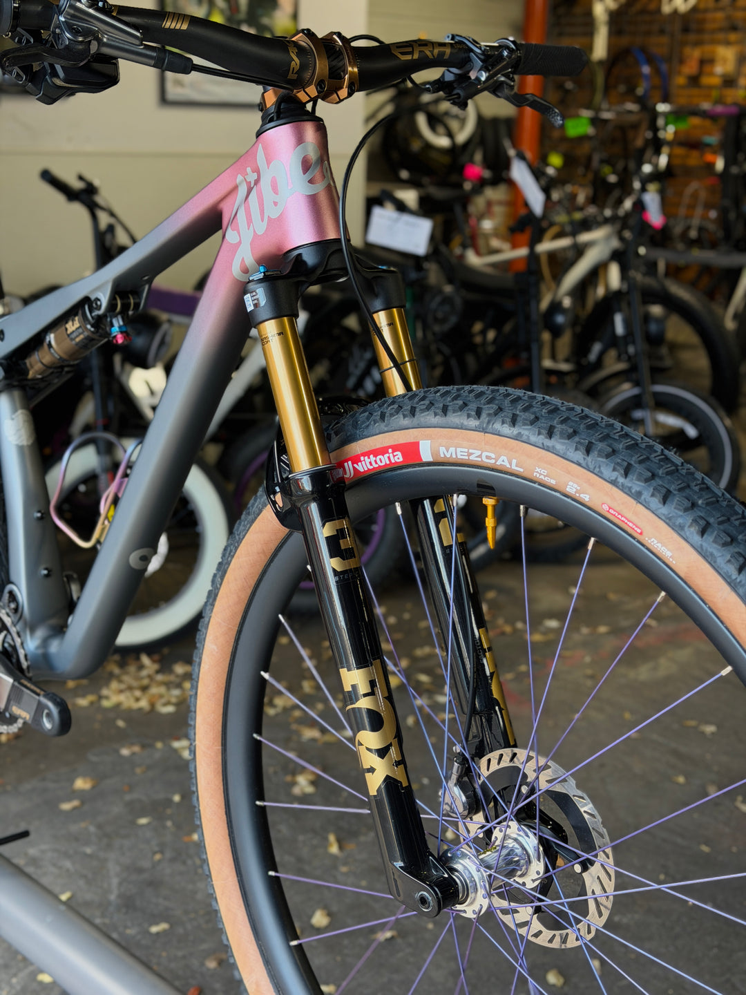 Close-up of a bicycle fork with visible branding in a bike shop setting