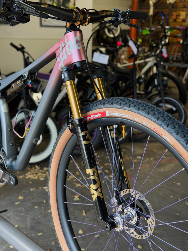 Close-up of a bicycle fork with visible branding in a bike shop setting