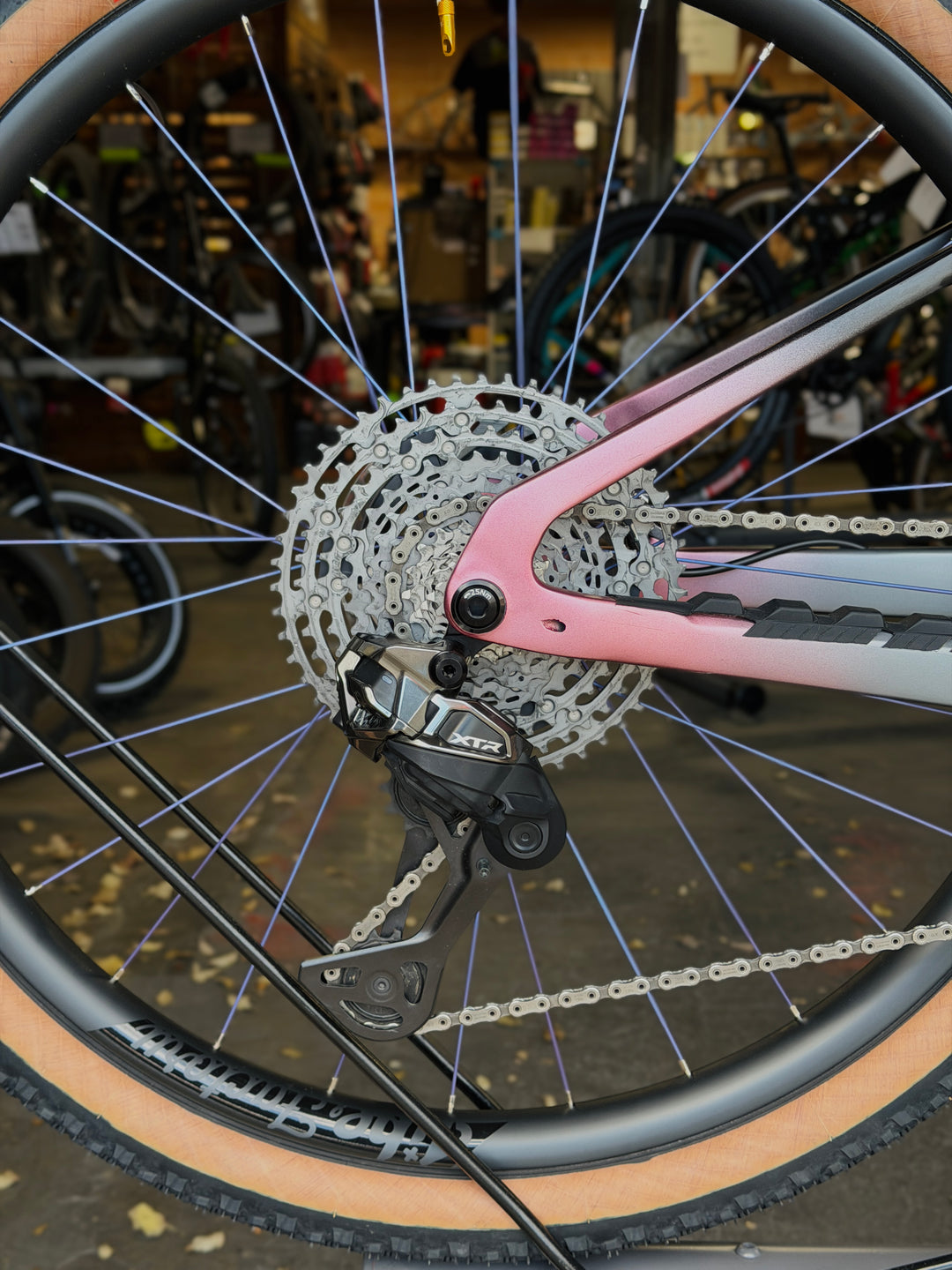 Close-up of a carbon fiber jibe factory bicycle wheel and Shimano XTR Di2 in a workshop setting