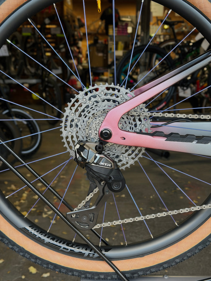 Close-up of a carbon fiber jibe factory bicycle wheel and Shimano XTR Di2 in a workshop setting